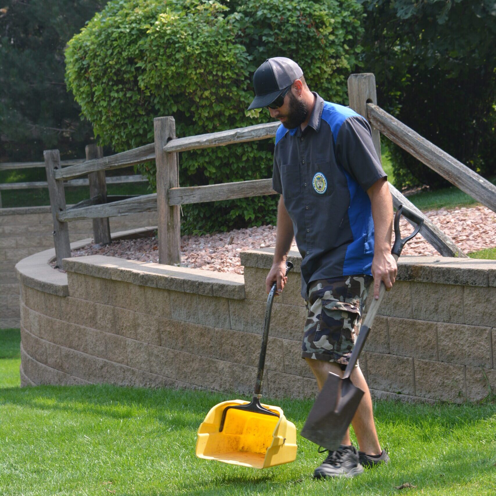 A person using a pooper scooper to clean up pet waste in Dacono, Colorado, ensuring a cleaner environment for local pet owners.